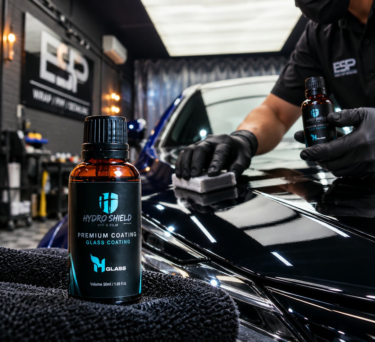 Technician applying Hydro Shield Glass Coating to a car bonnet at the ESP Wrap PPF Detailing workshop, rendered illustration