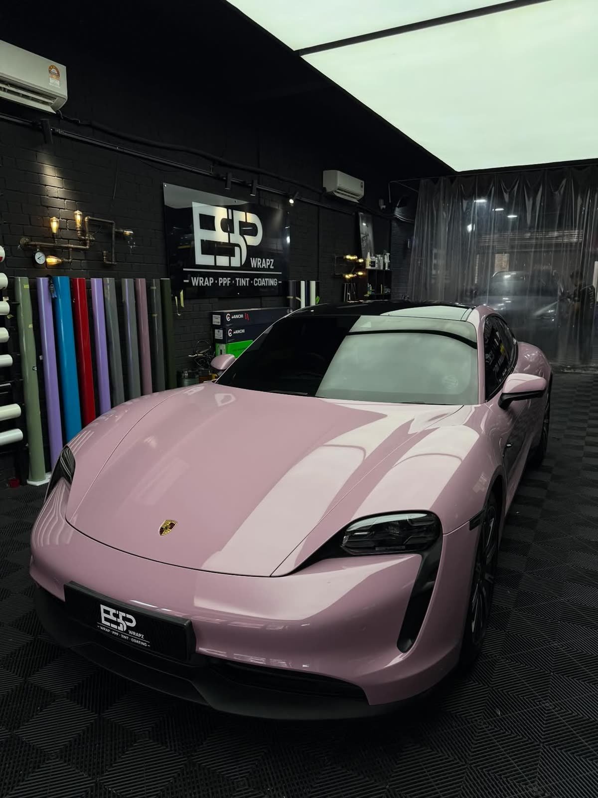 A pink Porsche Taycan, front three-quarter view inside the ESP Wrapz workshop
