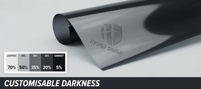 Unfurled window tint film roll with an embossed Hydro Shield logo and a customisable darkness percentage chart, rendered illustration